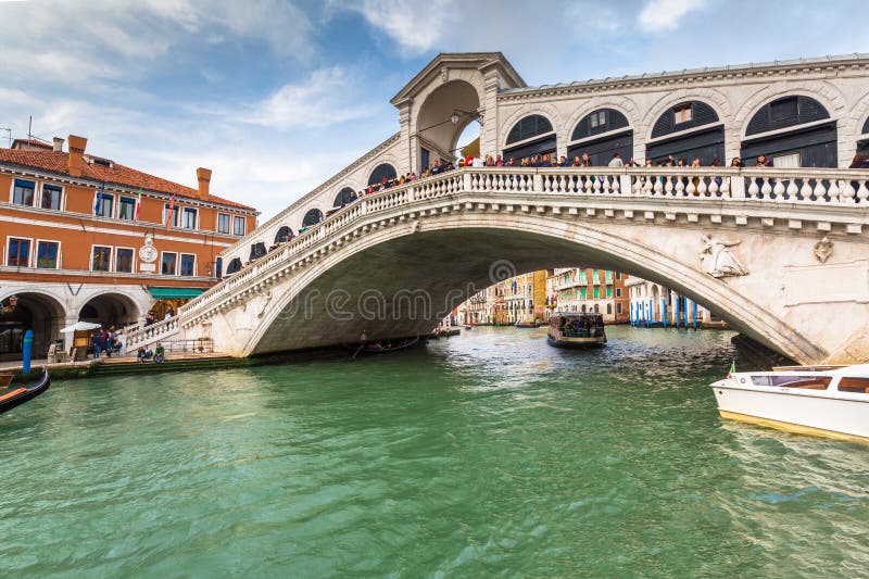 Venice, Italy - October 24, 2019: Ponte di Rialto bridge on the Grand canal of Venice city with traditional boats and colorful