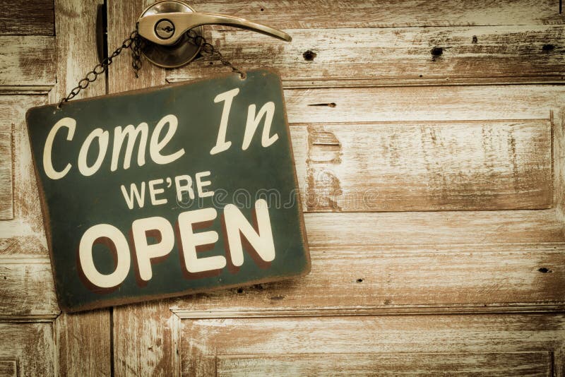 Venido adentro estamos abiertos en la puerta de madera, copyspace a la derecha V fotografía de archivo libre de regalías Venido adentro estamos abiertos en la puerta de madera, copyspace a la derecha V fotografía de archivo libre de regalías