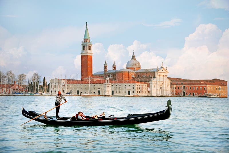 VENISE, ITALIE - 13 AVRIL 2015 : Belle vue de gondole traditionnelle sur le canal grand avec l'église de San Giorgio Maggiore dan photo stock VENISE, ITALIE - 13 AVRIL 2015 : Belle vue de gondole traditionnelle sur le canal grand avec l'église de San Giorgio Maggiore dan photo stock