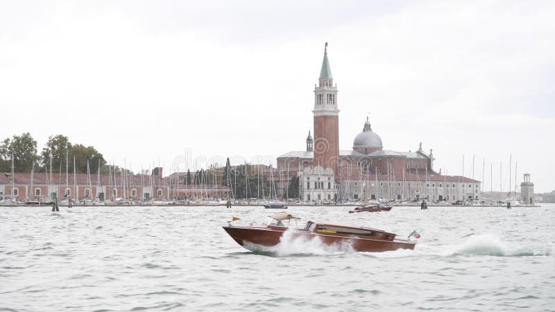 Venise, Italie- un navire de taxi se déplaçant rapidement devant l'église de San Giorgio Maggiore banque de vidéos