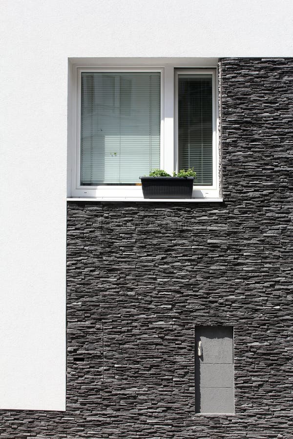 Ventana con la maceta en la pared de piedra foto de archivo Ventana con la maceta en la pared de piedra foto de archivo