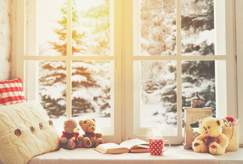 Christmas winter window with a book, a cup of hot tea and a teddy bear. Christmas winter window with a book, a cup of hot tea and a teddy bear