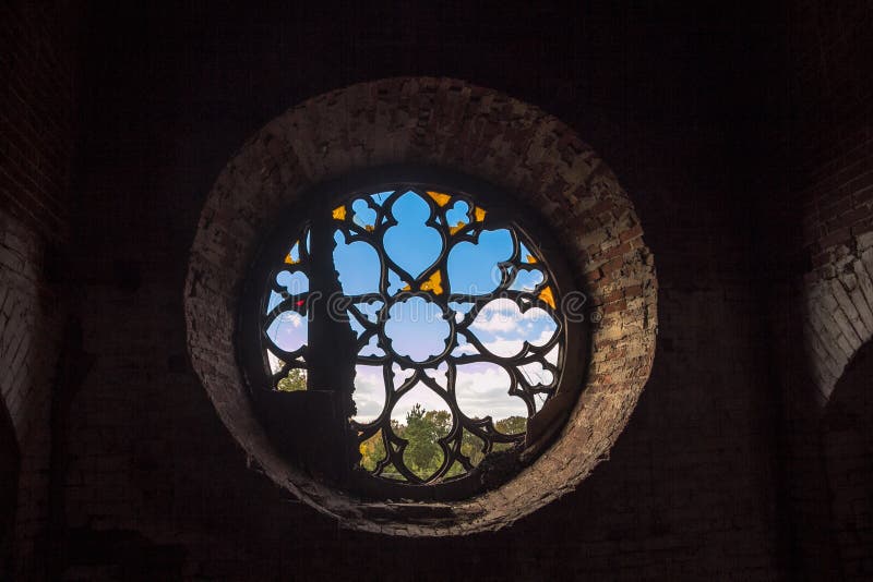 Ventana redonda del castillo con los vitrales quebrados foto de archivo libre de regalías Ventana redonda del castillo con los vitrales quebrados foto de archivo libre de regalías