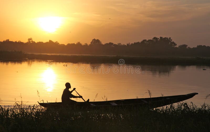 Silhouettes of a fisherman in his boat at sunset. Silhouettes of a fisherman in his boat at sunset