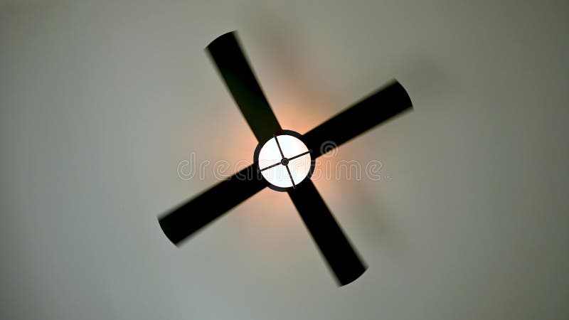 Ventilador de techo girando a baja velocidad con luz encendida