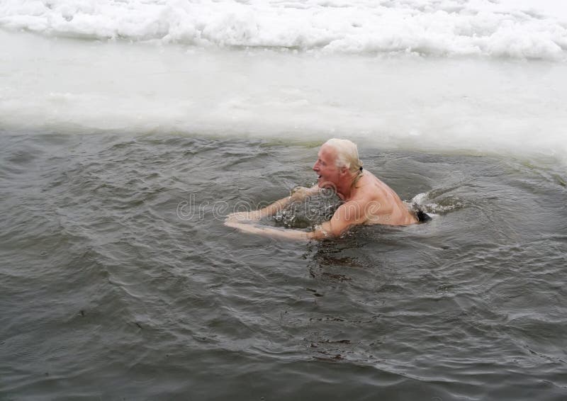 VILNIUS, LITHUANIA – FEBRUARY 5: Fans of winter swimming take a bath in some ice water on February 5, 2011 in Vilnius, Lithuania. VILNIUS, LITHUANIA – FEBRUARY 5: Fans of winter swimming take a bath in some ice water on February 5, 2011 in Vilnius, Lithuania.