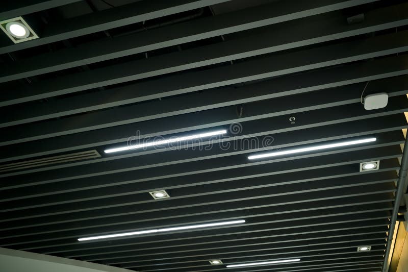 Ventilation and air conditioning system in industrial, exhibition hall or commercial premises with lighting, under the ceiling. Ventilation pipes and hoods