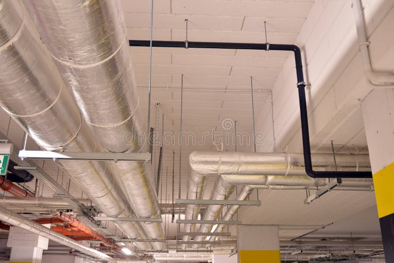 Water Pipes and Cable Trays Run Under Ceiling of a Building Stock Photo
