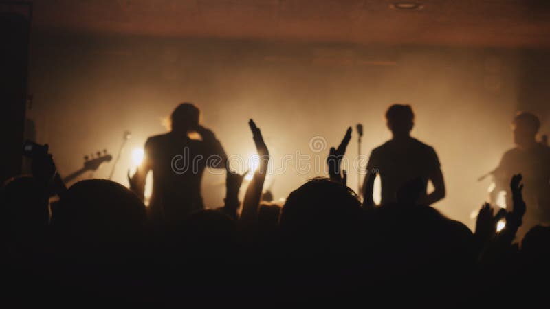 Fans waving their hands at a rock concert. Crowd partying at a concert or a night club. Fans waving their hands at a rock concert. Crowd partying at a concert or a night club.