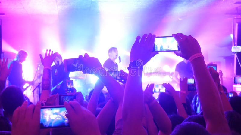 Fans hands recording video and taking pictures with smart phones at music concert. Fans hands recording video and taking pictures with smart phones at music concert.