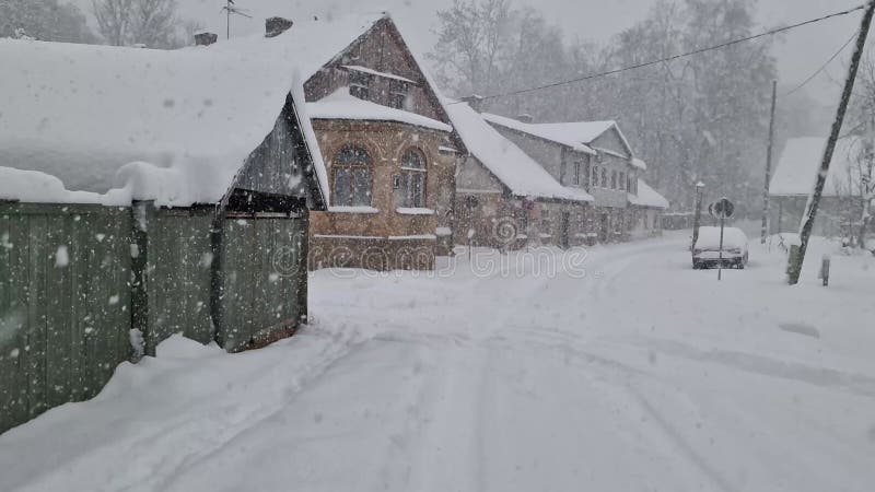 Ventisca en casas cubiertas de nieve en letonia en la calle.