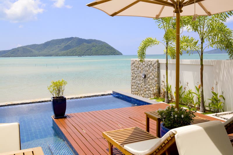 Veranda with chairs and an ocean view. A beautiful decorated veranda with deck chairs, umbrella and a view of the ocean and islands royalty free stock image Veranda with chairs and an ocean view. A beautiful decorated veranda with deck chairs, umbrella and a view of the ocean and islands royalty free stock image