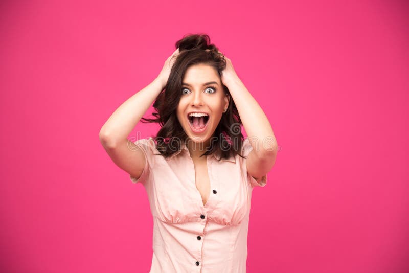 Verbaasde jonge vrouw die over roze achtergrond schreeuwen royalty-vrije stock foto Verbaasde jonge vrouw die over roze achtergrond schreeuwen royalty-vrije stock foto