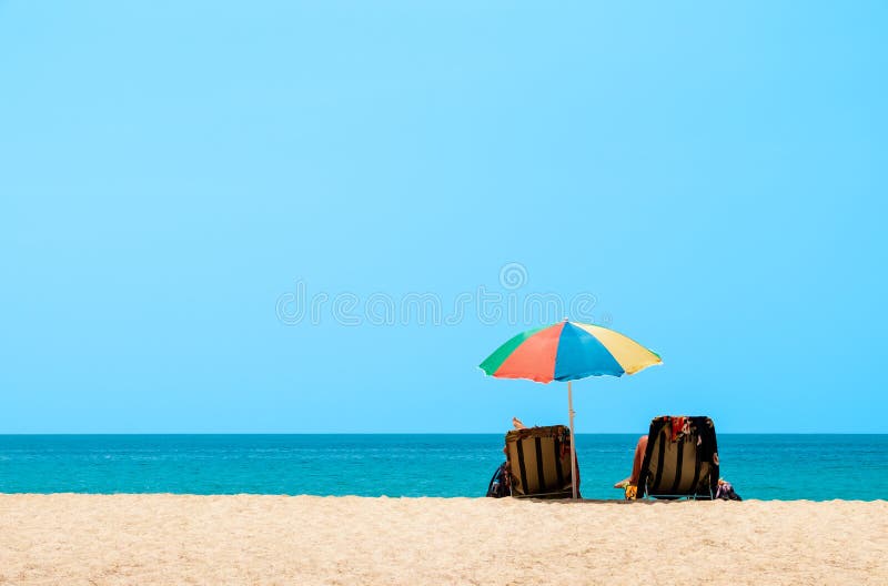 Verbinden Sie das Ein Sonnenbad nehmen und die Entspannung auf Strandstühlen Sande und Seeansicht, Sommerhintergrund stockfoto Verbinden Sie das Ein Sonnenbad nehmen und die Entspannung auf Strandstühlen Sande und Seeansicht, Sommerhintergrund stockfoto