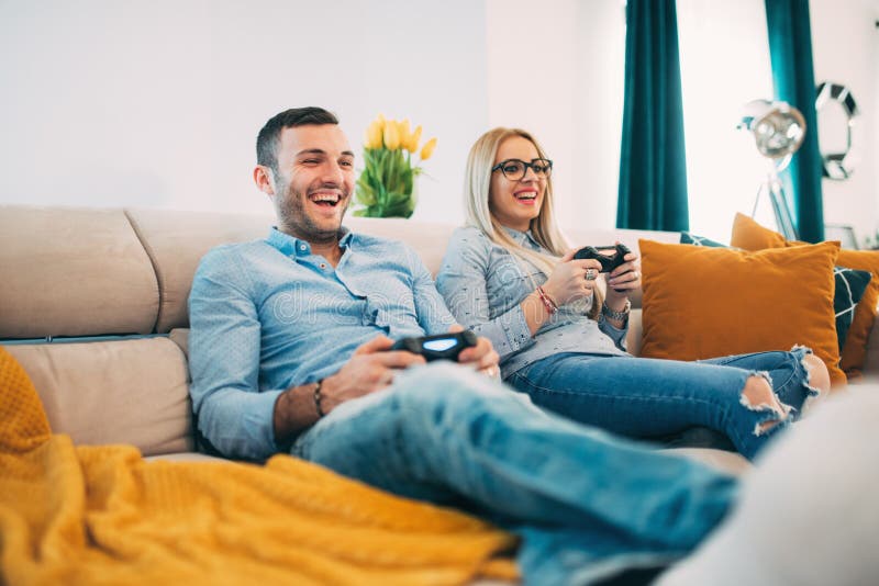 Verbinden Sie Haben des Spaßes und das Lachen beim Spielen von Videospielen im modernen Wohnzimmer stockfotografie Verbinden Sie Haben des Spaßes und das Lachen beim Spielen von Videospielen im modernen Wohnzimmer stockfotografie