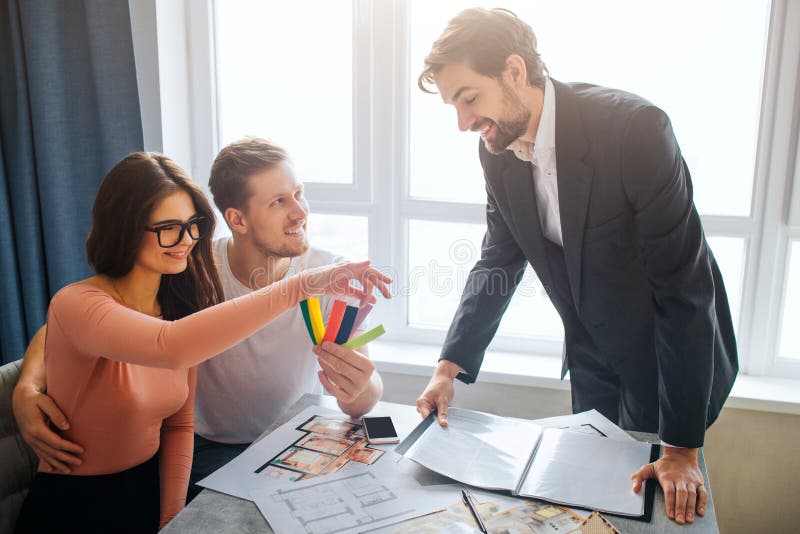 Verbinden Sie Kauf- oder Mietwohnung zusammen Netter junger Mann und Frau sitzen zusammen Sie wählt buntes Gewebestück kerl lizenzfreies stockfoto Verbinden Sie Kauf- oder Mietwohnung zusammen Netter junger Mann und Frau sitzen zusammen Sie wählt buntes Gewebestück kerl lizenzfreies stockfoto
