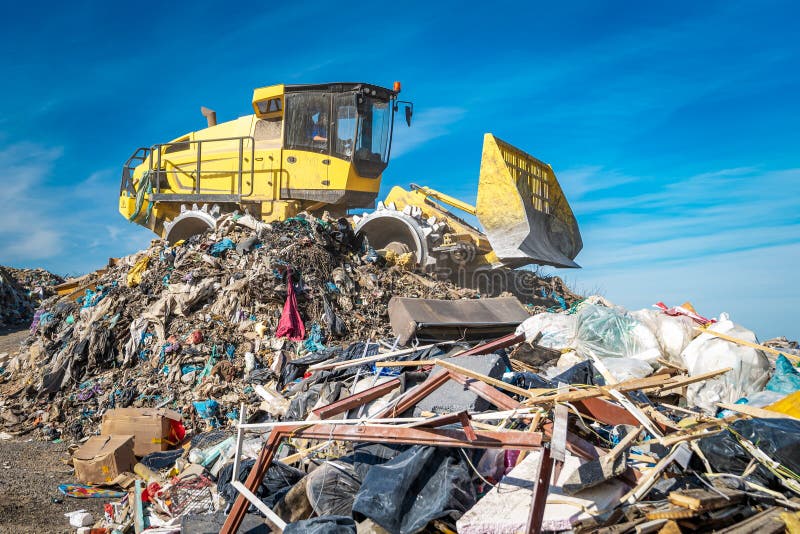 Compactor at a landfill processing municipal waste. Compactor at a landfill processing municipal waste.