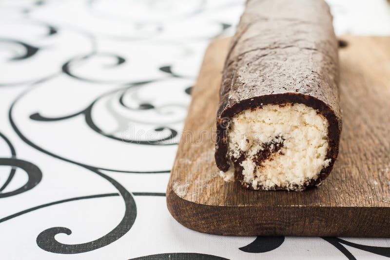 Verdrehte Rollenkokosnuß und -schokolade auf einem hölzernen Brett stockbild Verdrehte Rollenkokosnuß und -schokolade auf einem hölzernen Brett stockbild