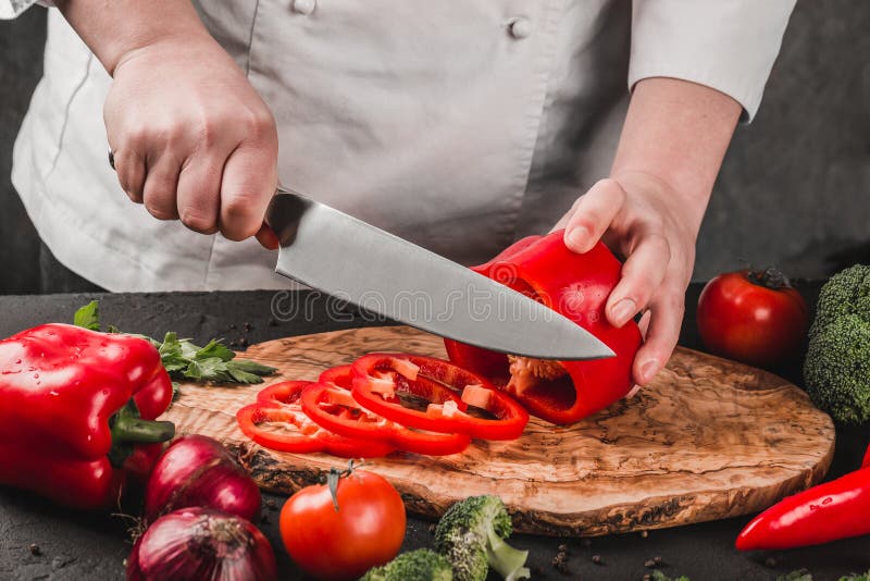 Verduras del corte del cocinero con el cuchillo en la cocina, cocinando la comida Ingredientes en la tabla Concepto sano del alim fotografía de archivo Verduras del corte del cocinero con el cuchillo en la cocina, cocinando la comida Ingredientes en la tabla Concepto sano del alim fotografía de archivo