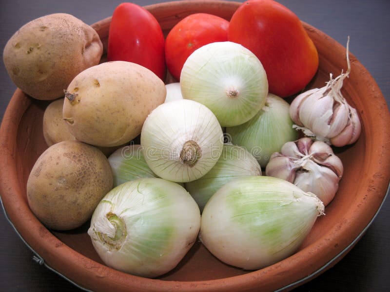 Verduras del tomate de la patata del ajo de la cebolla Primer de verduras orgánicas frescas en un plato de la arcilla fotografía de archivo libre de regalías Verduras del tomate de la patata del ajo de la cebolla Primer de verduras orgánicas frescas en un plato de la arcilla fotografía de archivo libre de regalías