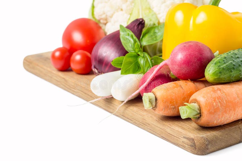 Verduras frescas en la tabla de cortar de madera en blanco imagenes de archivo Verduras frescas en la tabla de cortar de madera en blanco imagenes de archivo