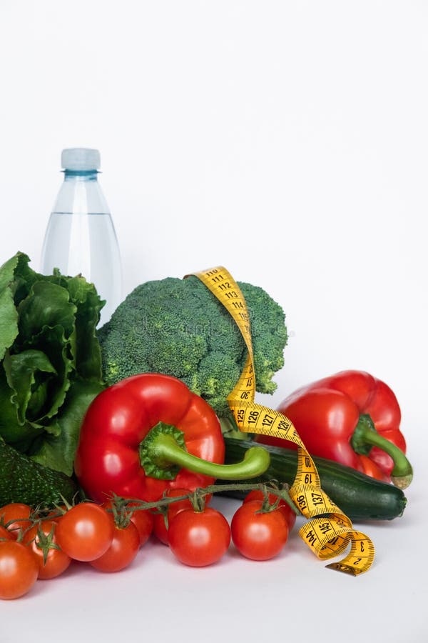 Verduras y agua con la línea de la cinta en el fondo blanco Concepto sano del alimento Copie el espacio imagenes de archivo Verduras y agua con la línea de la cinta en el fondo blanco Concepto sano del alimento Copie el espacio imagenes de archivo