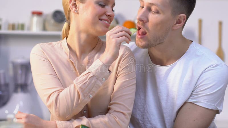 Verdure care d'alimentazione del ragazzo della ragazza attraente, coppie felici in cucina