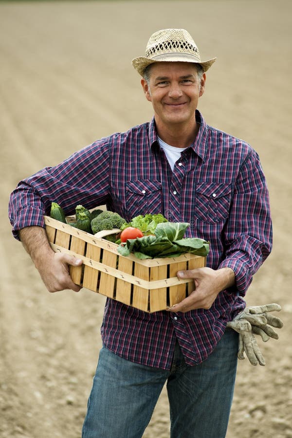 Farmer carrying a crate of vegetables. Farmer carrying a crate of vegetables