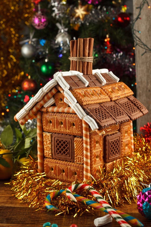 Verfraaid peperkoekhuis en Kerstmissnoepjes op de achtergrond van een geklede Kerstboom stock afbeelding Verfraaid peperkoekhuis en Kerstmissnoepjes op de achtergrond van een geklede Kerstboom stock afbeelding