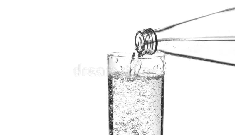 Sparkling water being poured from the neck of a bottle, close-up. Sparkling water being poured from the neck of a bottle, close-up