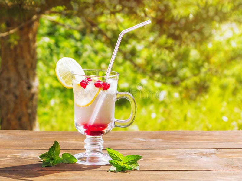 Verfrissende de zomercocktail met citroen, framboos en munt een houten lijst royalty-vrije stock fotografie Verfrissende de zomercocktail met citroen, framboos en munt een houten lijst royalty-vrije stock fotografie