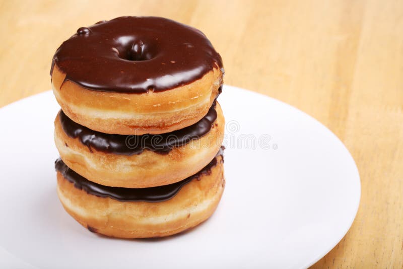 Drie chocoladeglazuurde donuts stock foto