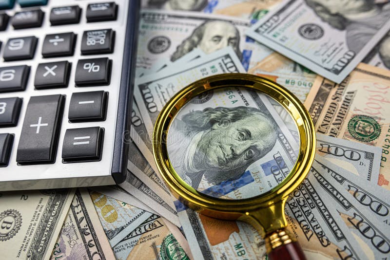Magnifying glass with calculator over US dollar bill. Finance and business, investment. Magnifying glass with calculator over US dollar bill. Finance and business, investment