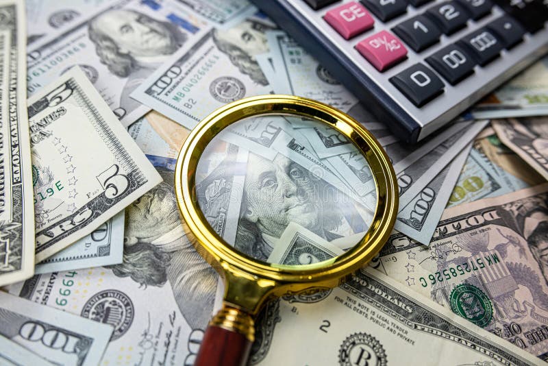 Magnifying glass with calculator over US dollar bill. Finance and business, investment. Magnifying glass with calculator over US dollar bill. Finance and business, investment