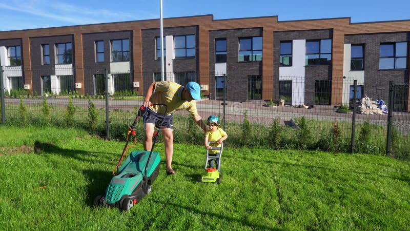 Verhoging van vader werk met kleine zoontje op tuin met grasmaaiers Gimbal-navolging