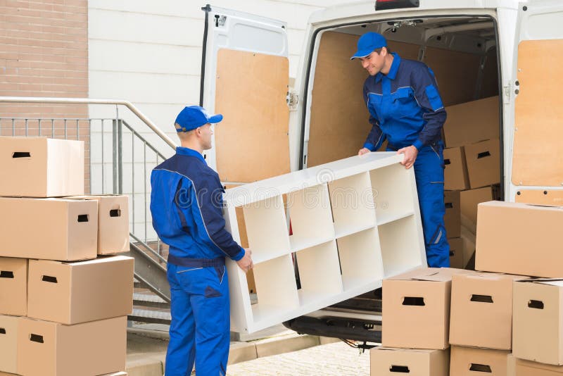 Verhuizers die Meubilair van Vrachtwagen leegmaken royalty-vrije stock afbeeldingen Verhuizers die Meubilair van Vrachtwagen leegmaken royalty-vrije stock afbeeldingen