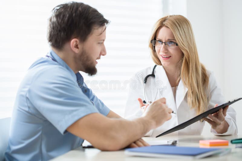 Two experienced physicians checking the patient's history. Two experienced physicians checking the patient's history