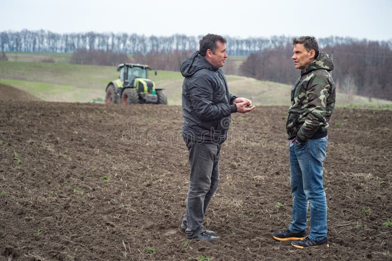 Verificações do agrônomo e do fazendeiro a umidade do solo antes do cer de sementeira imagem de stock Verificações do agrônomo e do fazendeiro a umidade do solo antes do cer de sementeira imagem de stock