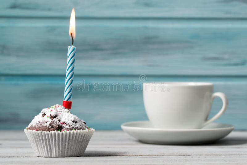 Verjaardag cupcake met kaars en kop van koffie, op houten achtergrond stock afbeelding Verjaardag cupcake met kaars en kop van koffie, op houten achtergrond stock afbeelding