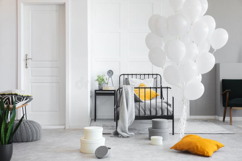 Verjaardagsviering in witte industriële slaapkamer met metaalbed en concrete vloer royalty-vrije stock foto's Verjaardagsviering in witte industriële slaapkamer met metaalbed en concrete vloer royalty-vrije stock foto's