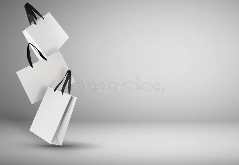 Verkauf. weiße Einkaufstüten in Luft auf Lichtgradientenuntergrund für Text lizenzfreie stockfotografie