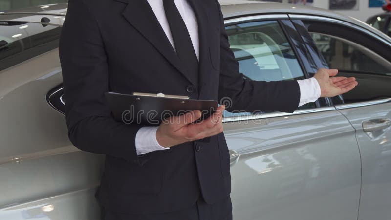 Verkaufsleiter zeigt seine Hand auf dem Auto lizenzfreies stockfoto Verkaufsleiter zeigt seine Hand auf dem Auto lizenzfreies stockfoto