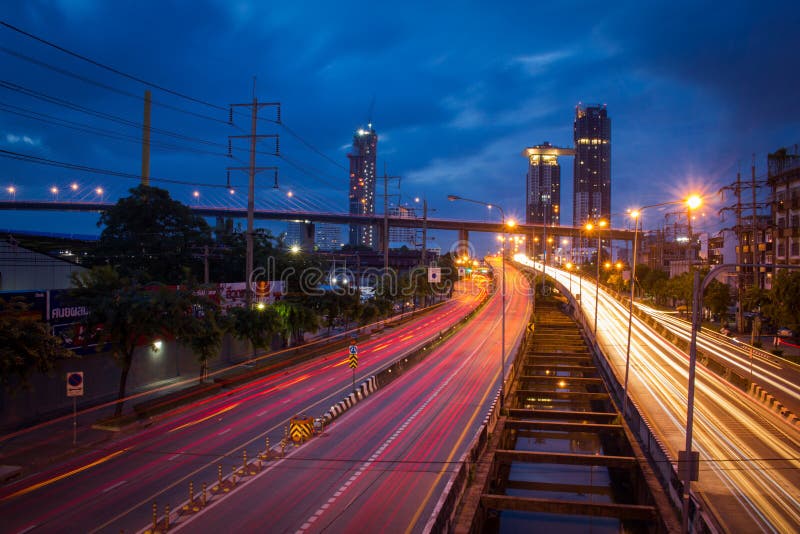 Verkeer op stadsweg door moderne gebouwen bij schemering in Thailand stock afbeeldingen Verkeer op stadsweg door moderne gebouwen bij schemering in Thailand stock afbeeldingen