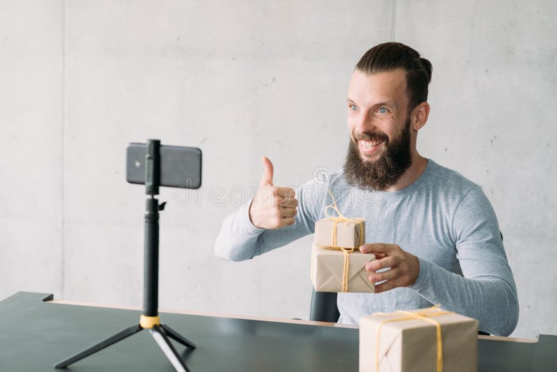 Sales management training. Hipster guy using smartphone on tripod to tell about tips for selling goods. Copy space. Sales management training. Hipster guy using smartphone on tripod to tell about tips for selling goods. Copy space.