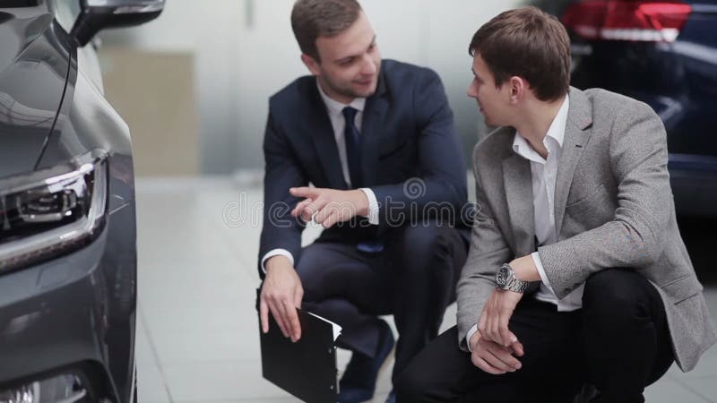 Verkoper en koper die gesprek hebben dichtbij wiel