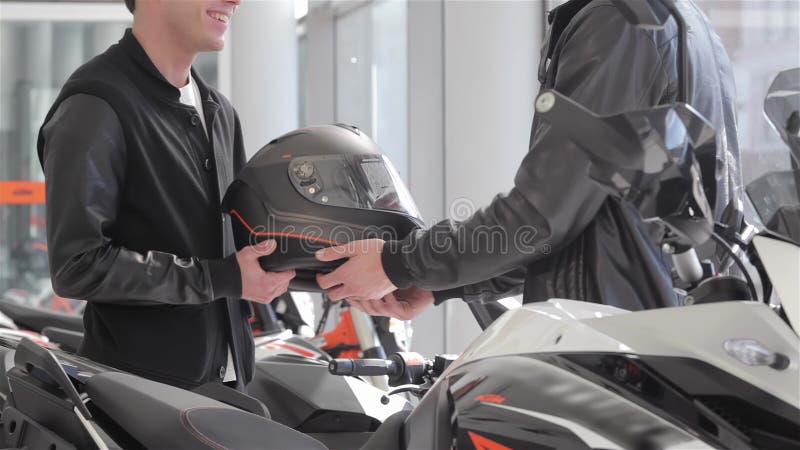 Verkoper geeft motorhelm aan koper