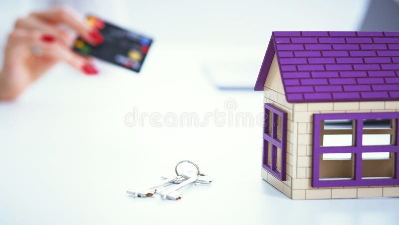 Verkäuferin hält eine Kreditkarte und die Berechnung eines Preises des Verkaufs des neuen Wohnungsbaudarlehens Vorbildliches Priv lizenzfreie stockfotografie Verkäuferin hält eine Kreditkarte und die Berechnung eines Preises des Verkaufs des neuen Wohnungsbaudarlehens Vorbildliches Priv lizenzfreie stockfotografie