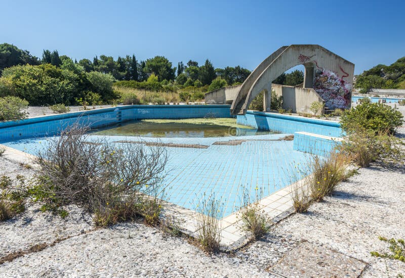 An abandoned lido complex on the island of rhodes in Greece where the swimming pools have filled with rain water and tuend green with algae. An abandoned lido complex on the island of rhodes in Greece where the swimming pools have filled with rain water and tuend green with algae