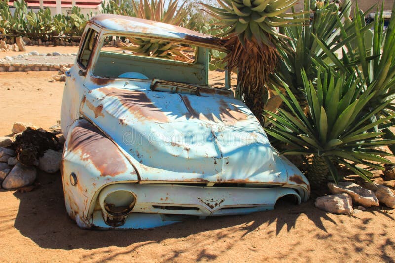 Verlaten oude roestige die auto's in de woestijn van Namibië door cactus dichtbij het Nationale Park namib-Naukluft wordt omringd stock afbeelding Verlaten oude roestige die auto's in de woestijn van Namibië door cactus dichtbij het Nationale Park namib-Naukluft wordt omringd stock afbeelding
