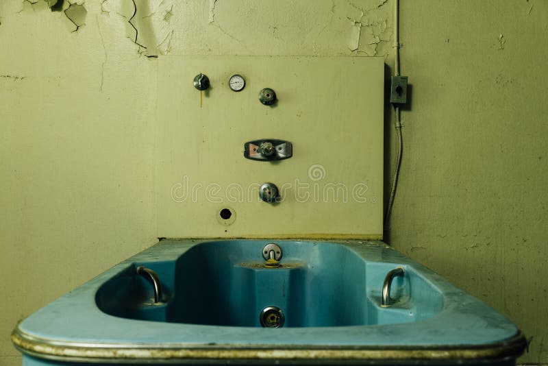 An interior view of a derelict hydrotherapy bathtub at an abandoned hospital. An interior view of a derelict hydrotherapy bathtub at an abandoned hospital.